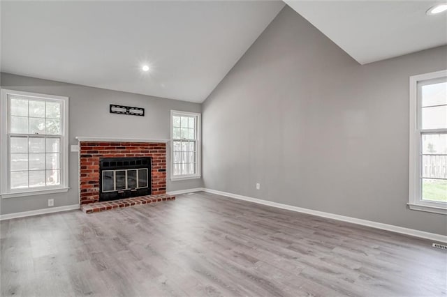 12321 W 105th Ter, Overland Park, KS 66215 - unfurnished living room with lofted ceiling, wood finished floors, a brick fireplace, and recessed lighting