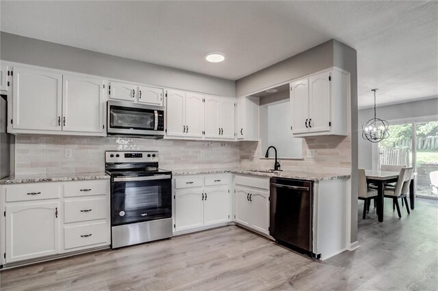 12321 W 105th Ter, Overland Park, KS 66215 - kitchen with stainless steel appliances, white cabinets, light wood-style flooring, backsplash, and a chandelier