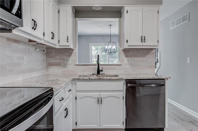 12321 W 105th Ter, Overland Park, KS 66215 - kitchen featuring stainless steel appliances, white cabinetry, a chandelier, and decorative backsplash