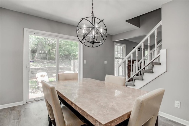 12321 W 105th Ter, Overland Park, KS 66215 - dining area featuring a chandelier, stairs, and wood finished floors