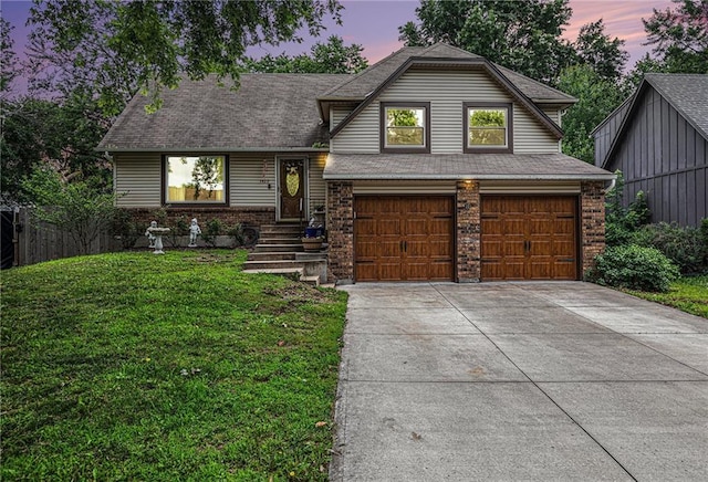 1422 S Kiowa Dr, Olathe, KS 66062 - tri-level home featuring an attached garage, concrete driveway, a yard, brick siding, and a shingled roof