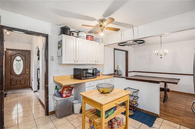 1422 S Kiowa Dr, Olathe, KS 66062 - kitchen featuring light tile patterned floors, white cabinetry, a ceiling fan, a textured ceiling, and decorative light fixtures