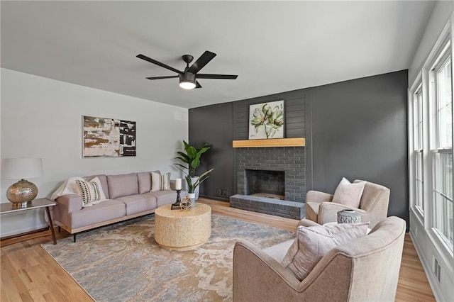 811 NW Maynard St, Blue Springs, MO 64015 - living area with wood finished floors, a ceiling fan, and a fireplace