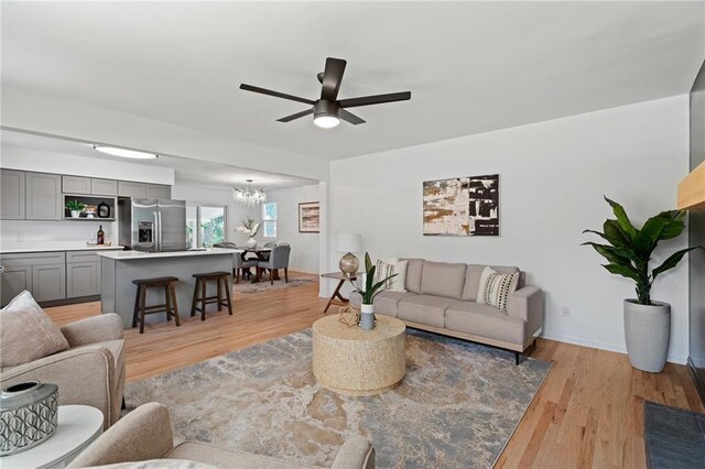 811 NW Maynard St, Blue Springs, MO 64015 - living area with a chandelier, a ceiling fan, and light wood-type flooring