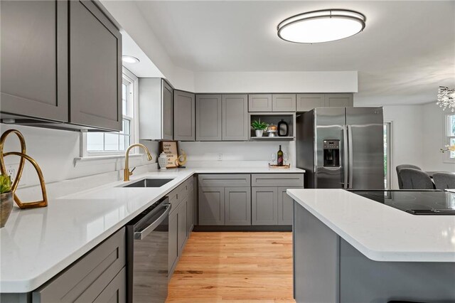 811 NW Maynard St, Blue Springs, MO 64015 - kitchen with stainless steel appliances, gray cabinets, open shelves, light wood-style floors, and light countertops