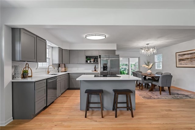 811 NW Maynard St, Blue Springs, MO 64015 - kitchen featuring stainless steel appliances, gray cabinets, light countertops, and a chandelier