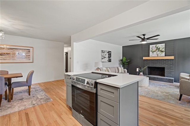 811 NW Maynard St, Blue Springs, MO 64015 - kitchen with stainless steel range with electric stovetop, gray cabinets, open floor plan, light wood-type flooring, and light countertops