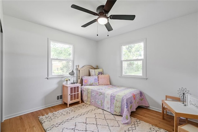 811 NW Maynard St, Blue Springs, MO 64015 - bedroom with multiple windows, wood finished floors, and ceiling fan
