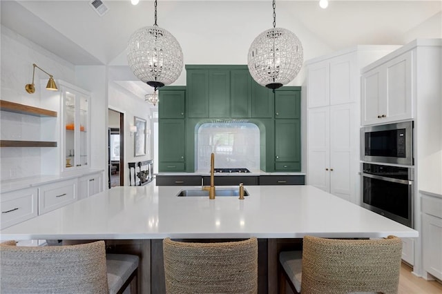 1128 Hillswick Ln, Raymore, MO 64083 - kitchen featuring appliances with stainless steel finishes, a chandelier, vaulted ceiling, green cabinetry, and light countertops