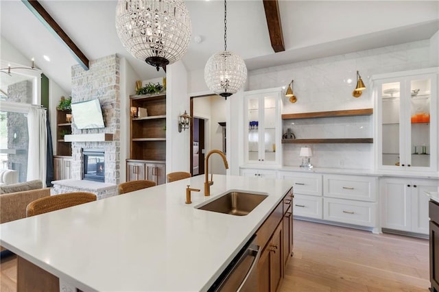 1128 Hillswick Ln, Raymore, MO 64083 - kitchen with a chandelier, open shelves, beamed ceiling, light countertops, and light wood-style flooring