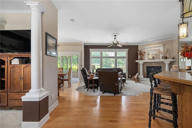 4148 SE Paddock Dr, Lees Summit, MO 64082 - dining area with ornate columns, a ceiling fan, crown molding, light wood finished floors, and a glass covered fireplace