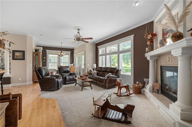 4148 SE Paddock Dr, Lees Summit, MO 64082 - living room featuring ornamental molding, plenty of natural light, light wood-style floors, ceiling fan, and a glass covered fireplace