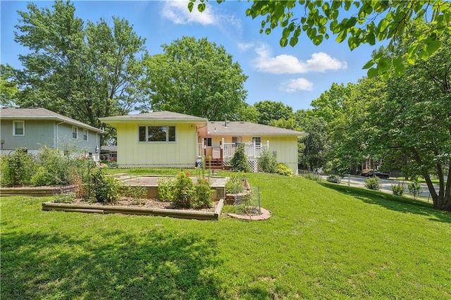 304 SE Moore St, Blue Springs, MO 64014 - rear view of house featuring a vegetable garden, a deck, and board and batten siding