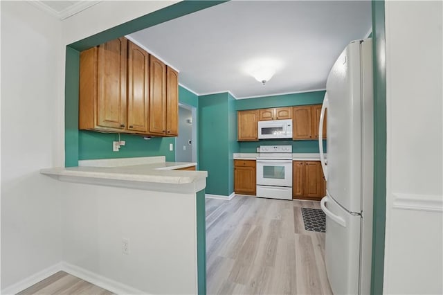 304 SE Moore St, Blue Springs, MO 64014 - kitchen featuring white appliances, light wood-style floors, a peninsula, brown cabinets, and crown molding