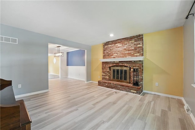 304 SE Moore St, Blue Springs, MO 64014 - unfurnished living room with wood finished floors, a fireplace, recessed lighting, and a chandelier