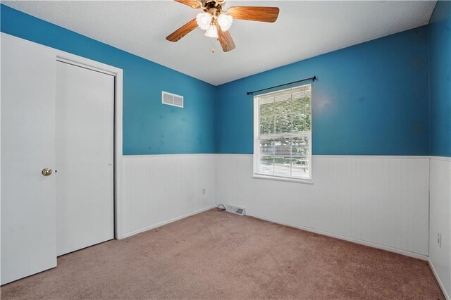304 SE Moore St, Blue Springs, MO 64014 - unfurnished bedroom with a wainscoted wall, carpet floors, ceiling fan, and a closet