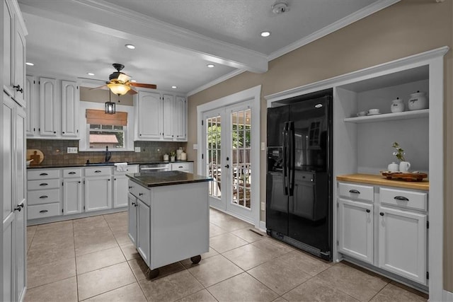 6424 Floyd St, Overland Park, KS 66202 - kitchen featuring black fridge, white cabinets, tasteful backsplash, french doors, and dark countertops