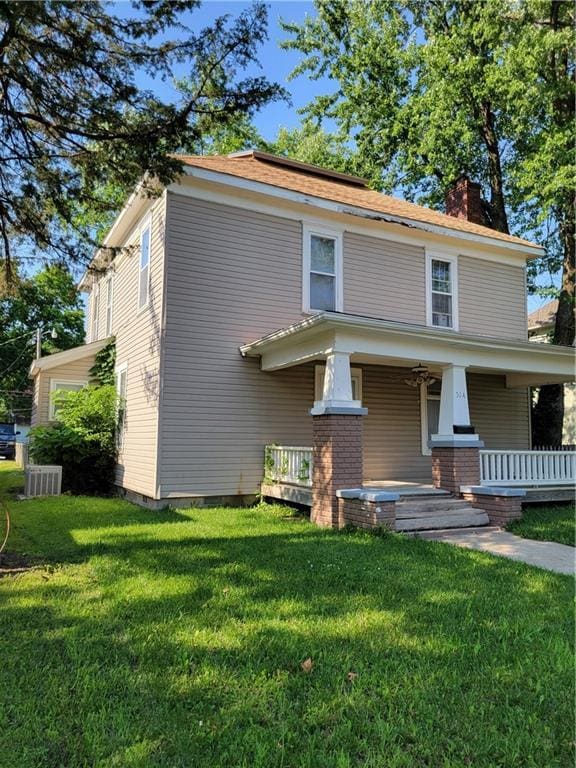 514 E Jackson Ave, Iola, KS 66749 - american foursquare style home featuring a chimney, a porch, and a front yard