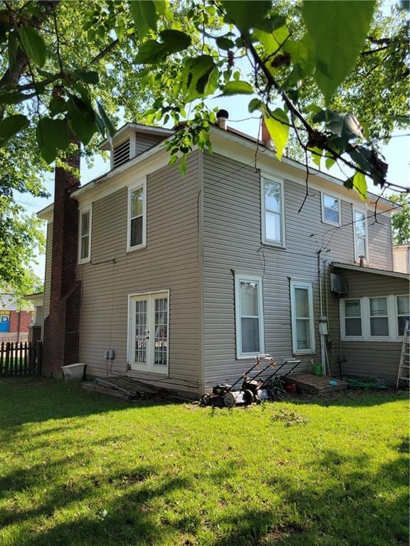 514 E Jackson Ave, Iola, KS 66749 - rear view of house featuring french doors and a chimney