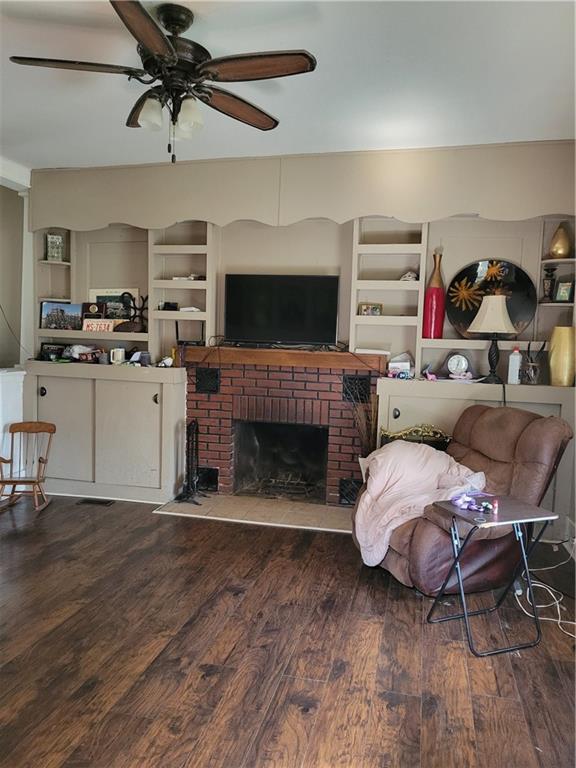 514 E Jackson Ave, Iola, KS 66749 - living area featuring a ceiling fan, wood finished floors, and a fireplace