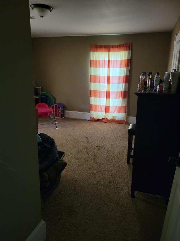 514 E Jackson Ave, Iola, KS 66749 - bedroom with carpet flooring and baseboards