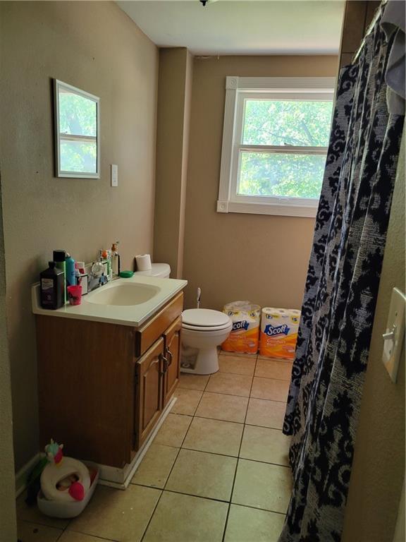 514 E Jackson Ave, Iola, KS 66749 - full bathroom with tile patterned flooring, vanity, and curtained shower