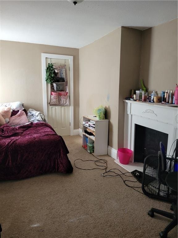 514 E Jackson Ave, Iola, KS 66749 - bedroom with light colored carpet and a fireplace with flush hearth
