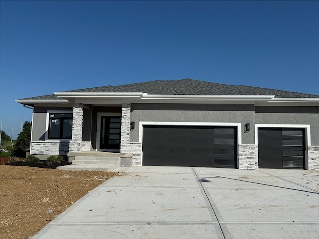 8810 N Agnes Ave, Kansas City, MO 64156 - prairie-style home featuring an attached garage, driveway, and stucco siding