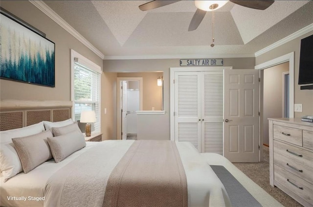 2541 NE Dale Hunter Ln, Lees Summit, MO 64086 - carpeted bedroom featuring a closet, a raised ceiling, ornamental molding, ensuite bathroom, and a ceiling fan