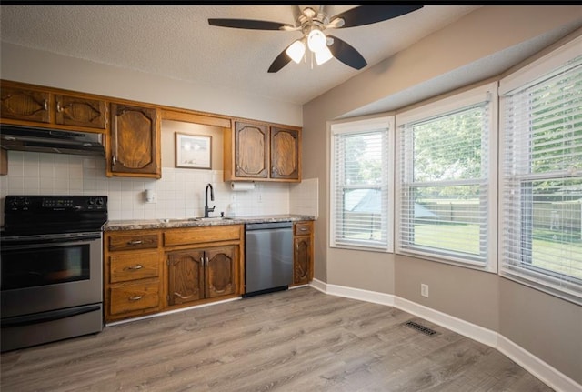 2541 NE Dale Hunter Ln, Lees Summit, MO 64086 - kitchen featuring stainless steel appliances, range hood, backsplash, a ceiling fan, and light wood-type flooring