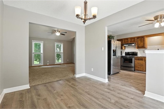 2541 NE Dale Hunter Ln, Lees Summit, MO 64086 - kitchen with appliances with stainless steel finishes, a ceiling fan, brown cabinets, and under cabinet range hood