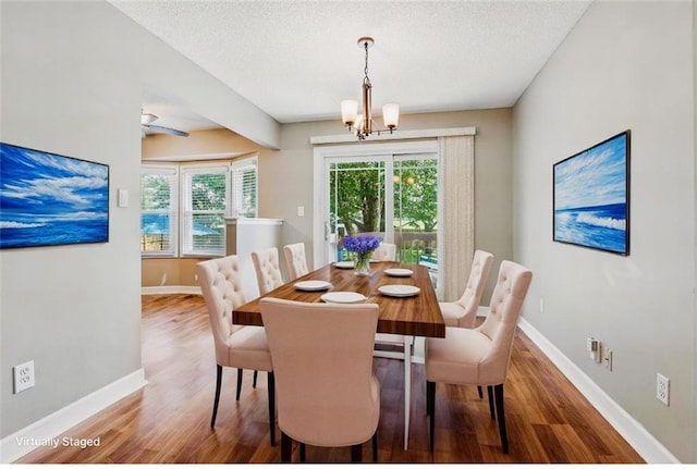 2541 NE Dale Hunter Ln, Lees Summit, MO 64086 - dining area with wood finished floors, a chandelier, and a textured ceiling