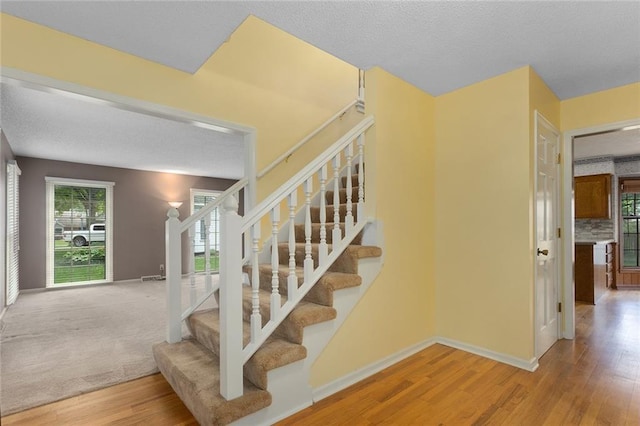 13220 W 76th St, Lenexa, KS 66216 - staircase featuring wood finished floors and a textured ceiling