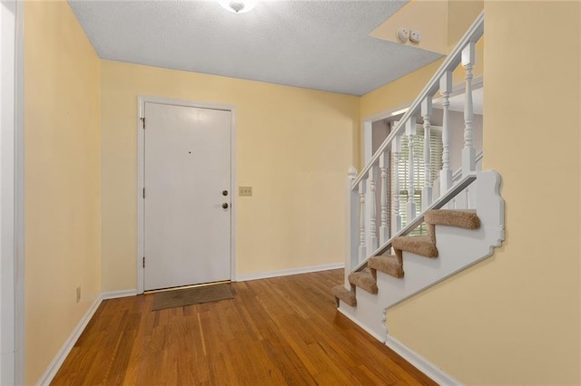 13220 W 76th St, Lenexa, KS 66216 - foyer entrance with stairs, wood finished floors, and a textured ceiling