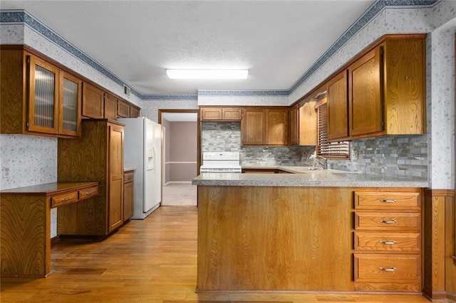 13220 W 76th St, Lenexa, KS 66216 - kitchen with wallpapered walls, stove, white refrigerator with ice dispenser, light wood-style flooring, and a peninsula