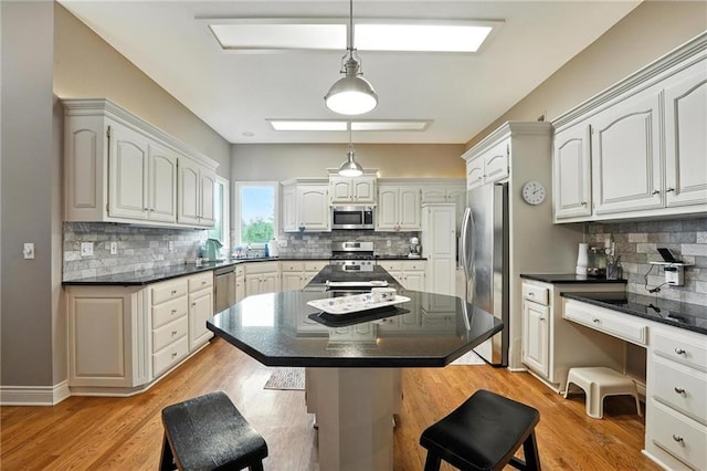 5708 Cottonwood St, Shawnee, KS 66216 - kitchen with stainless steel appliances, dark countertops, a kitchen breakfast bar, and decorative backsplash