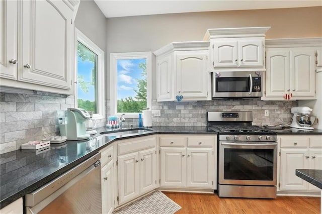 5708 Cottonwood St, Shawnee, KS 66216 - kitchen featuring stainless steel appliances, light wood-type flooring, white cabinetry, and backsplash