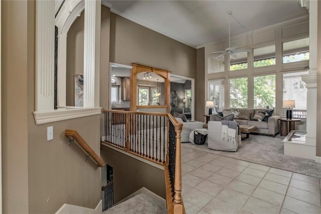 19326 W 98th St, Lenexa, KS 66220 - living room with tile patterned flooring, a ceiling fan, carpet flooring, plenty of natural light, and ornamental molding