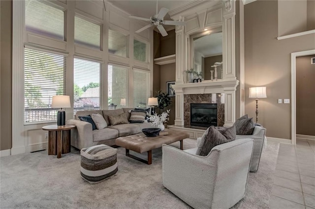 19326 W 98th St, Lenexa, KS 66220 - living area featuring ornamental molding, ceiling fan, a high end fireplace, a high ceiling, and light tile patterned flooring