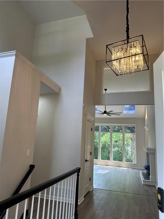 1411 NE 85th Ter, Kansas City, MO 64155 - hallway featuring a towering ceiling, an upstairs landing, wood finished floors, and a chandelier