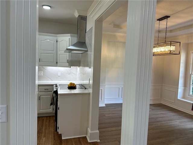 1411 NE 85th Ter, Kansas City, MO 64155 - kitchen featuring wall chimney range hood, dark wood-style flooring, light countertops, white cabinetry, and decorative light fixtures