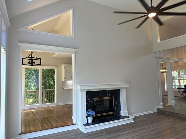 1411 NE 85th Ter, Kansas City, MO 64155 - unfurnished living room with wood finished floors, a towering ceiling, a ceiling fan, and a premium fireplace