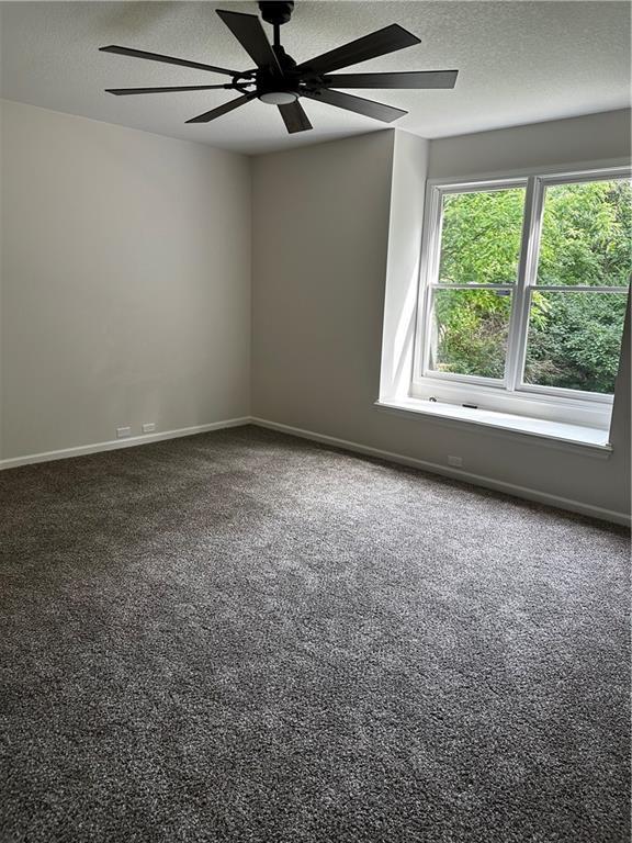 1411 NE 85th Ter, Kansas City, MO 64155 - carpeted empty room featuring a textured ceiling and a ceiling fan