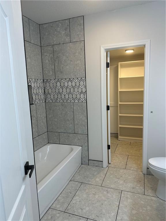 1411 NE 85th Ter, Kansas City, MO 64155 - bathroom featuring  shower combination and tile patterned floors