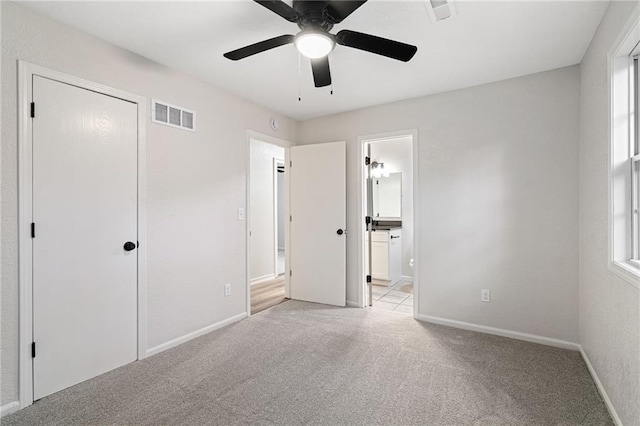 508 N Lincoln St, Olathe, KS 66061 - unfurnished bedroom featuring light colored carpet, connected bathroom, and a ceiling fan
