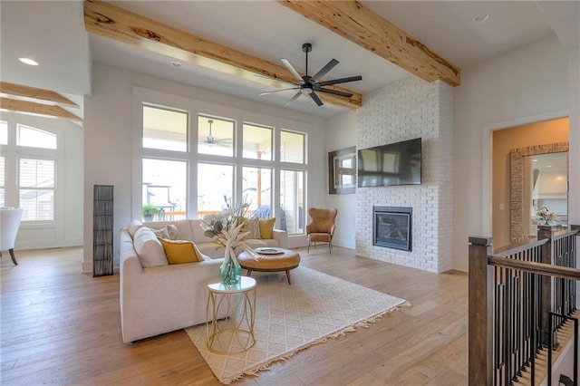 12605 W 169th St, Overland Park, KS 66221 - living area featuring a ceiling fan, beamed ceiling, a fireplace, and wood finished floors