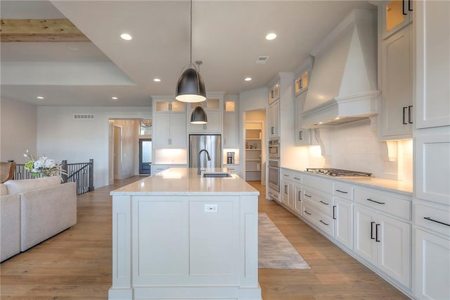12605 W 169th St, Overland Park, KS 66221 - kitchen featuring premium range hood, appliances with stainless steel finishes, tasteful backsplash, recessed lighting, and light wood finished floors