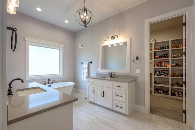 12605 W 169th St, Overland Park, KS 66221 - bathroom featuring vanity, a soaking tub, a walk in closet, a chandelier, and recessed lighting