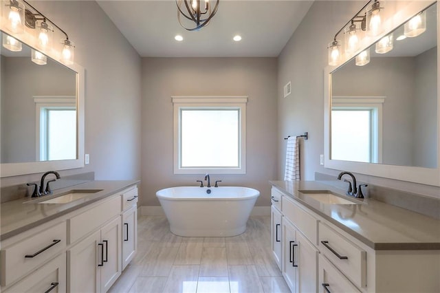 12605 W 169th St, Overland Park, KS 66221 - full bathroom with marble look tile flooring, two vanities, healthy amount of natural light, and recessed lighting