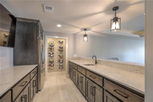 12605 W 169th St, Overland Park, KS 66221 - kitchen featuring stainless steel refrigerator, hanging light fixtures, light stone countertops, light tile patterned floors, and recessed lighting